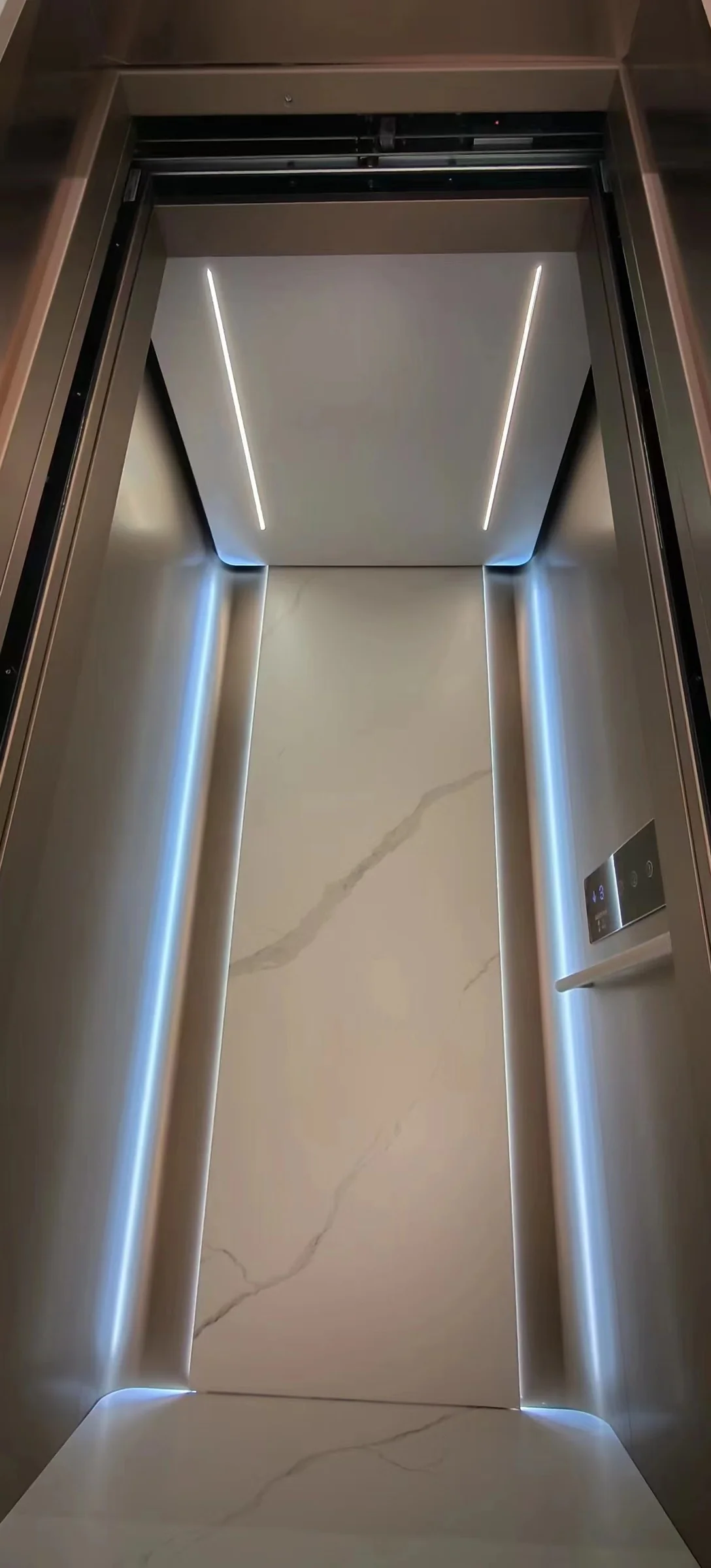 Lift cabin with stainless steel finishes and a handrail